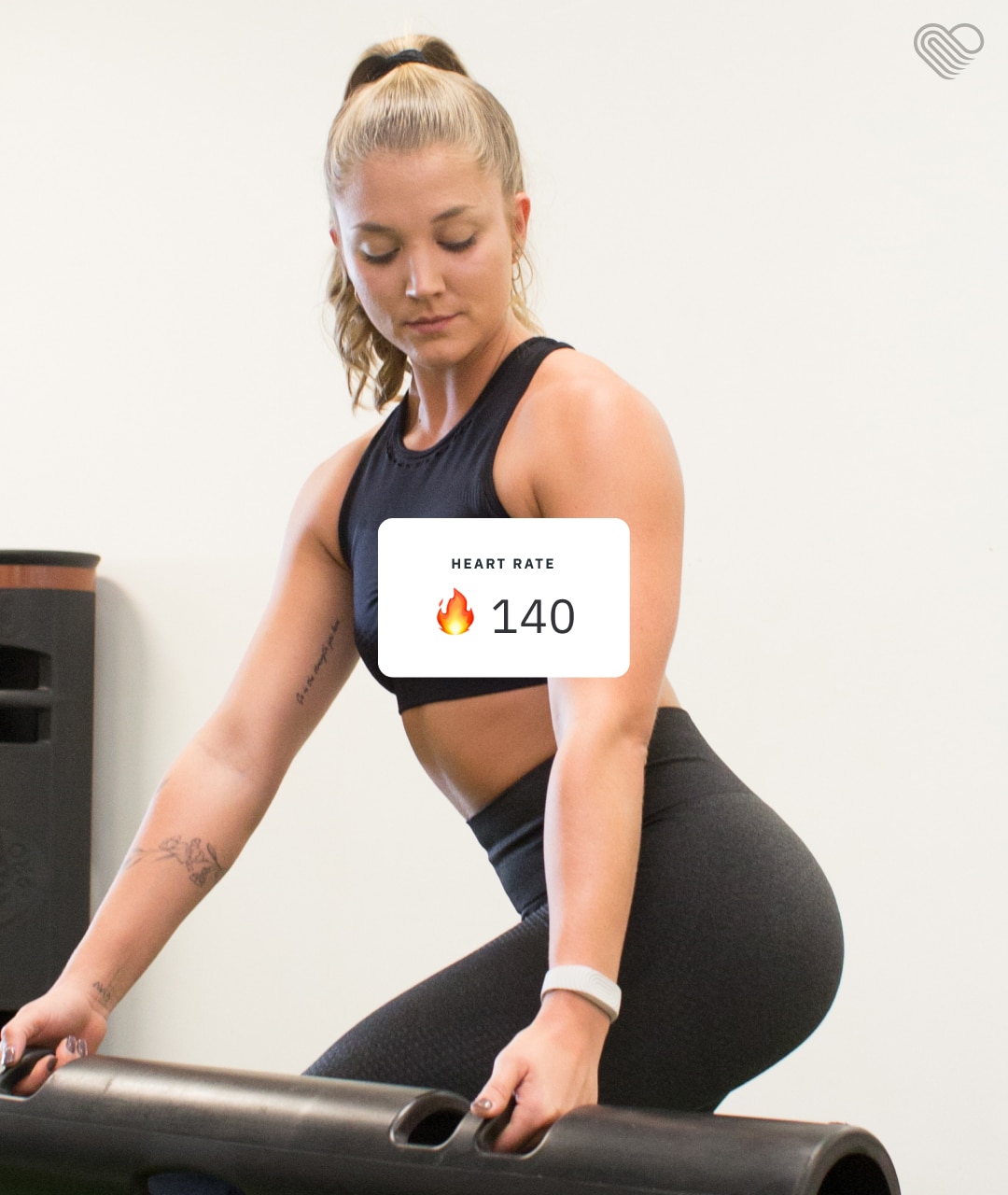 A woman in athletic clothing exercises while her heart rate monitor shows 140 BPM. Fitness tracking at its best for optimal performance and health monitoring.